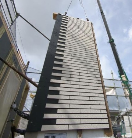 外壁パネルをクレーンで吊っているところ